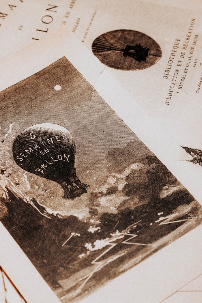 about-us-01 Antique print depicting a hot air balloon with French text, exuding a vintage aesthetic.